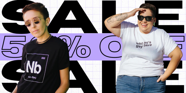 two people model autostraddle tee shirts. one of the models is wearing a nonbinary shirt that says "nb" and the other wearing a shirt that says "who all's gay here" words behind them read "SALE 50% off"