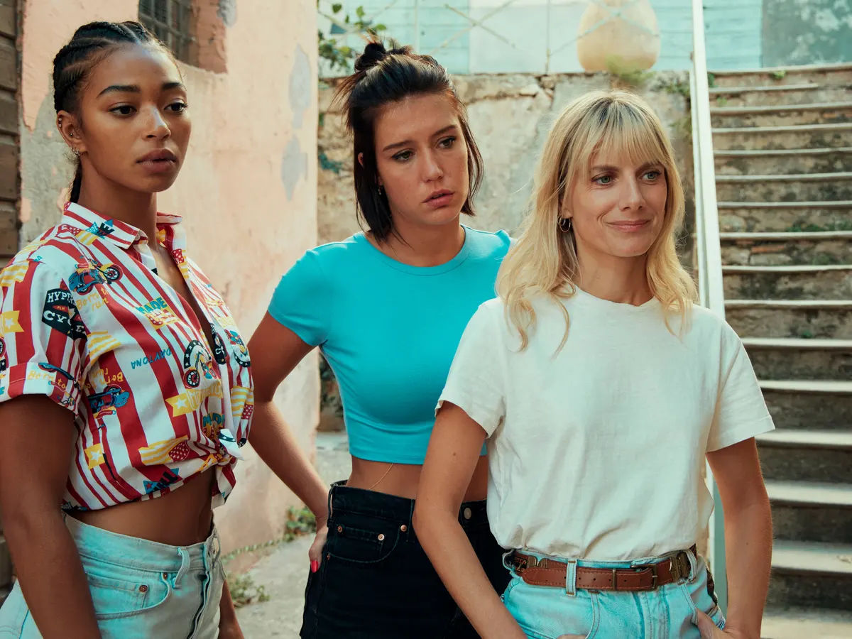 Wingwomen: Manon Bresch, Adèle Exarchopoulos, and Mélanie Laurent stand next to each other. They're all wearing pants, Laurent is in a white t-shirt, Bresch and Exarchopoulos are wearing crop tops.