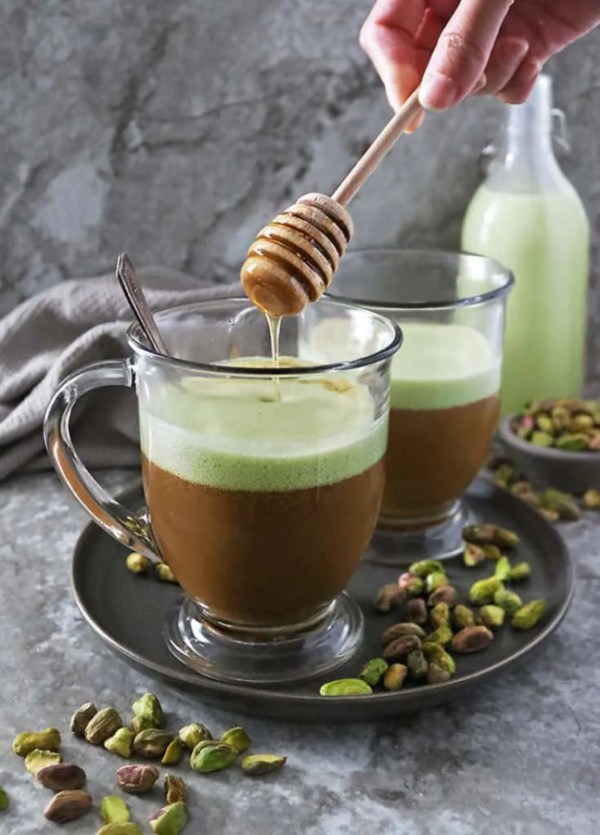 a clear mug of pistachio latte