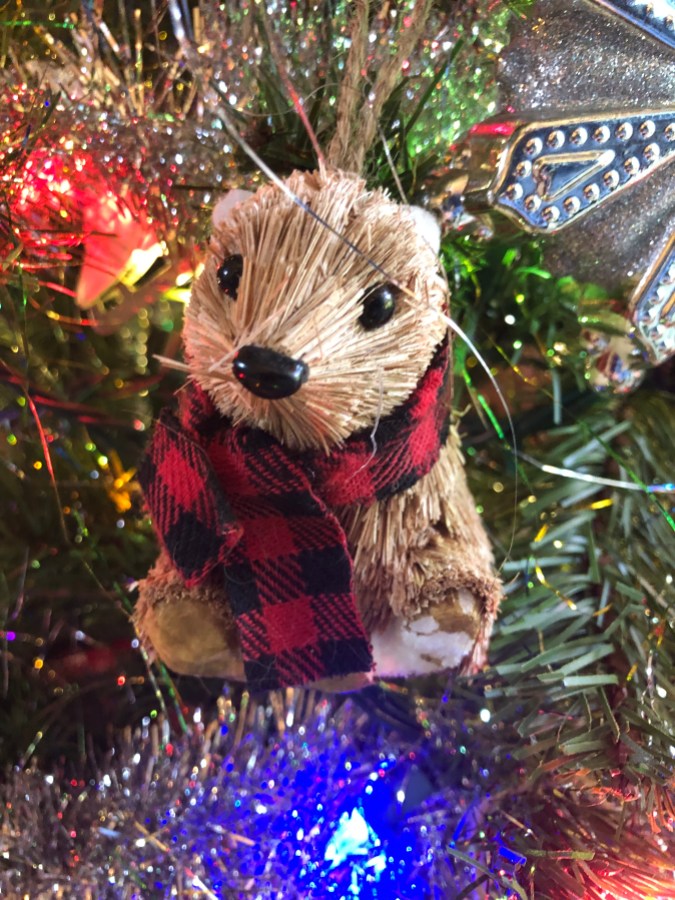 a groundhog ornament wearing a red and black scarf