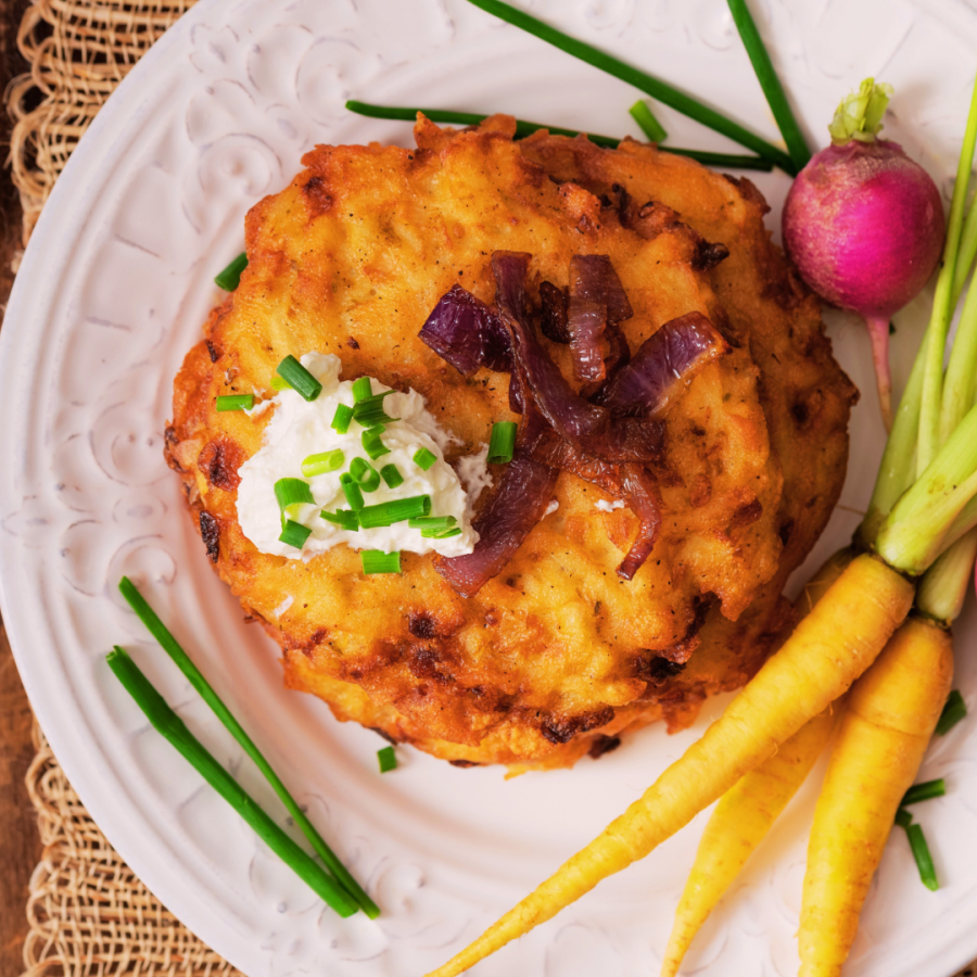 latkes on a plate with decorative carrots and radishes