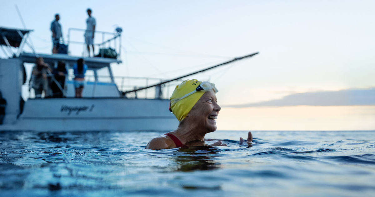 Annette Bening as Diana Nyad smiles while in the water next to a boat