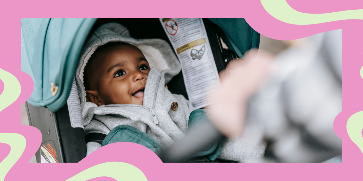 a baby smiling in a stroller