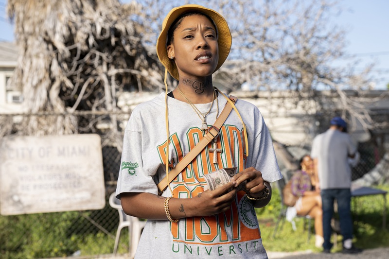 Rap Sh!t: Chastity counts her money. She's wearing a Florida A&M t-shirt and a crossbody bag with a matching bucket cap.