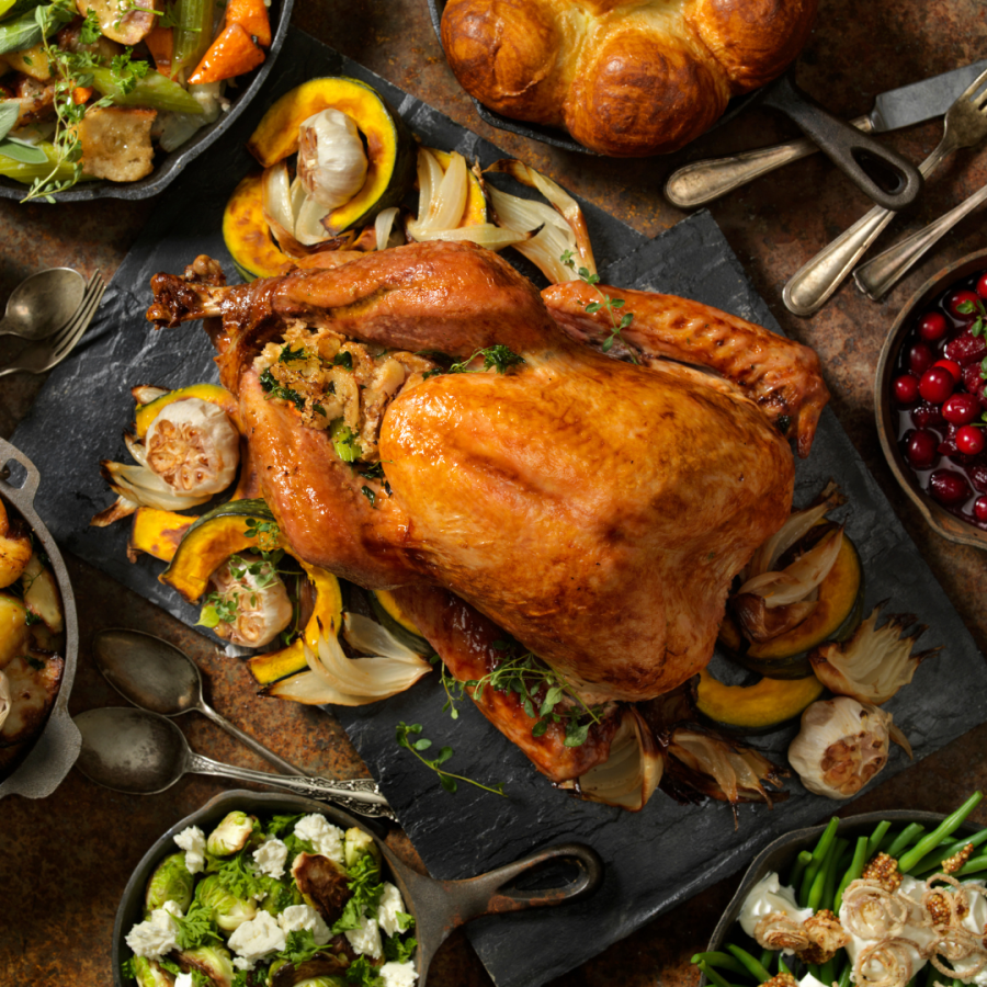 a roast turkey in the center of a beautiful table spread