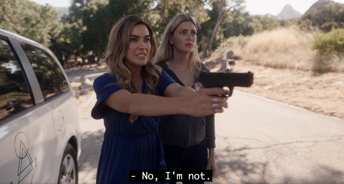 Chrishell Stause holding a gun and saying "no, I'm not"