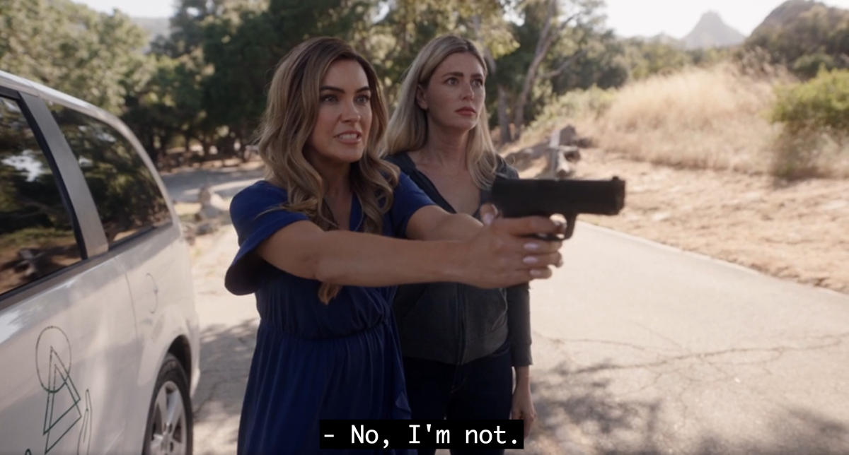 Chrishell Stause holding a gun and saying "no, I'm not"