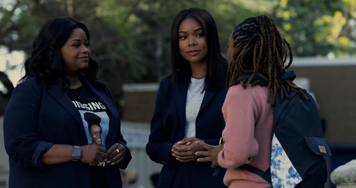 Two women and a young girl stand outside their car, looking concerned