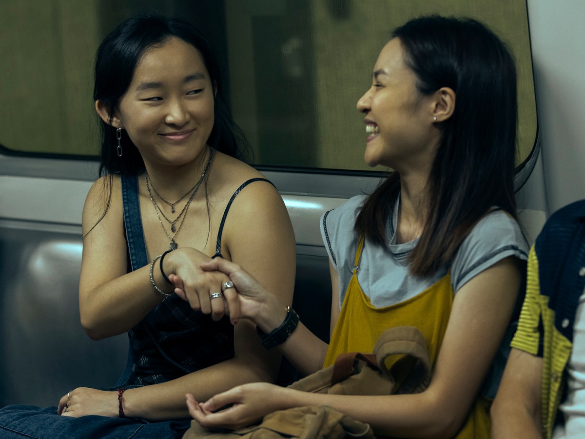 two girls on a subway train laughing in "Expats" on prime video
