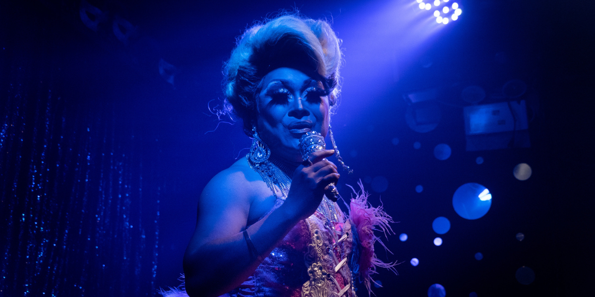 drag queen performing in blue light
