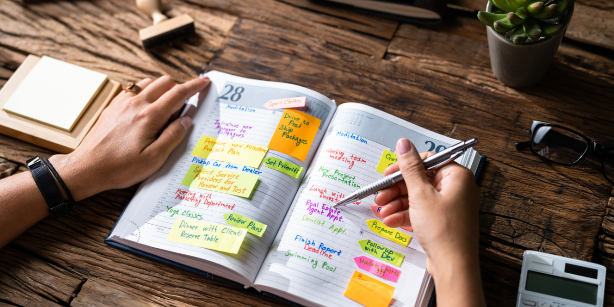 a person filling out a very busy personal planner schedule