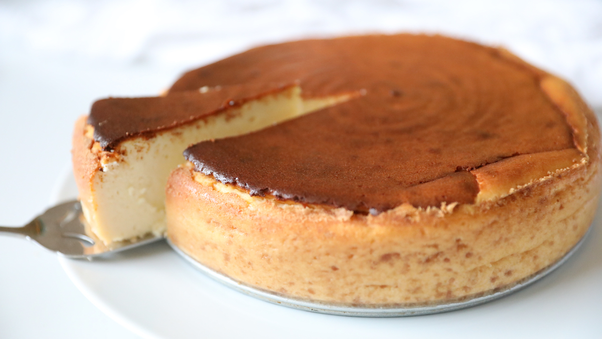 Italian Christmas desserts: a slice of ricotta cheesecake being pulled out from a full cake