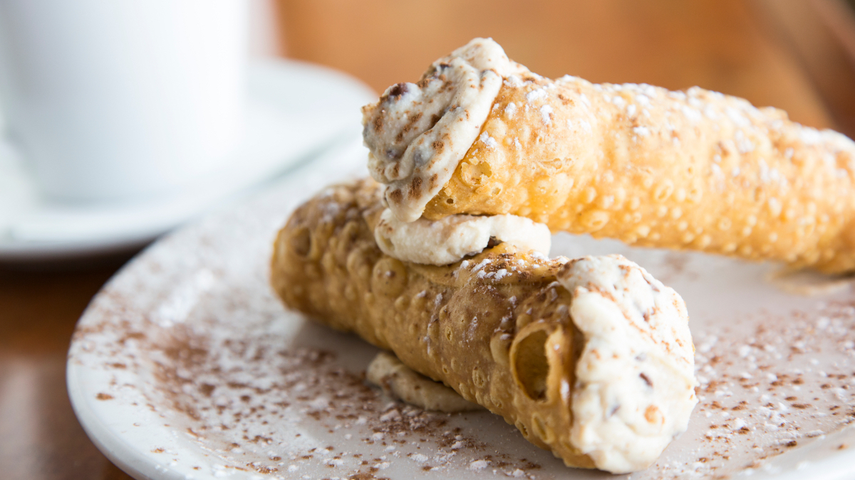 Italian Christmas Desserts: A close up of two cannolis one on top of the other