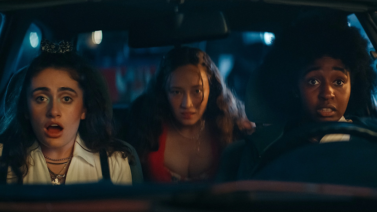 Best queer movies of 2023: Ayo Edebiri and Rachel Sennott sit in the front seat of a car with Havana Rose Liu in the back. They all look surprised. 