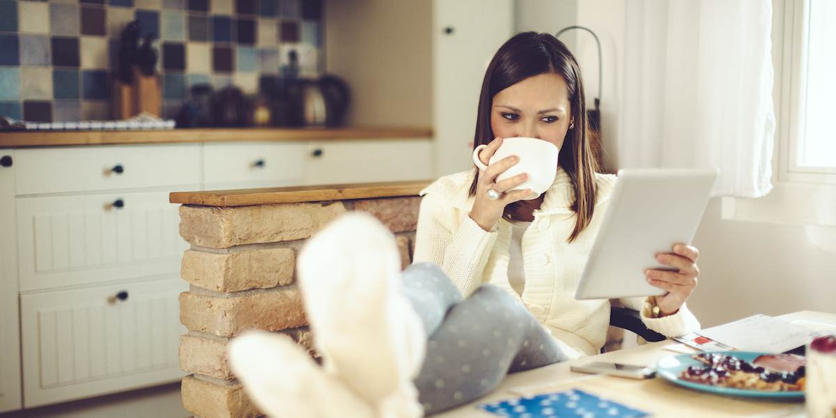 Beautiful young woman is having breakfast in the kitchen