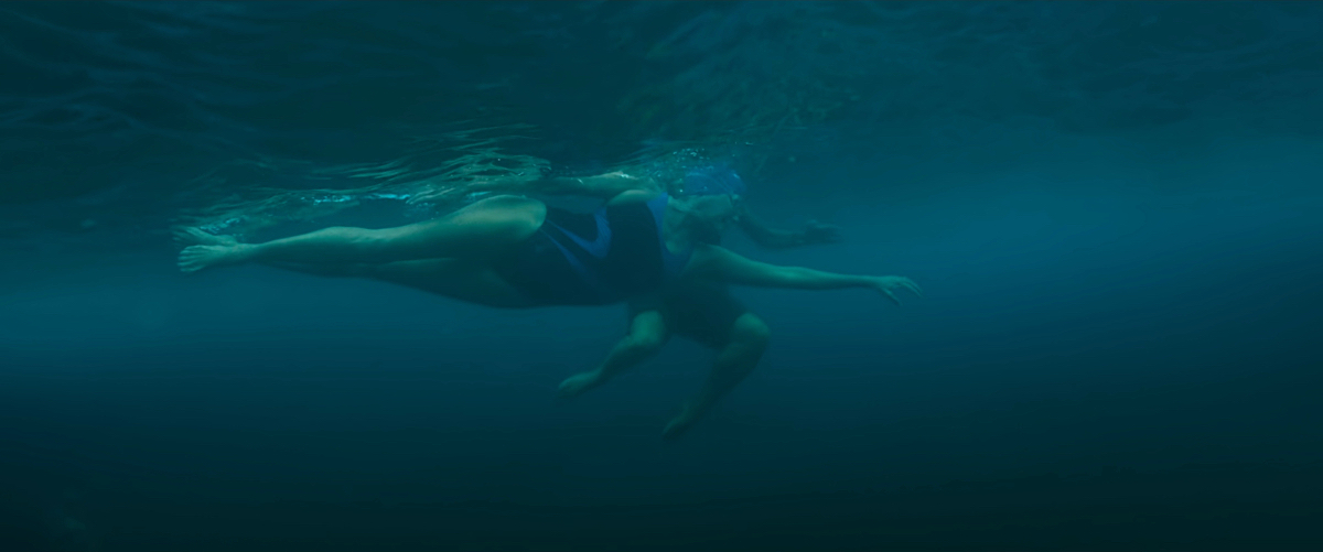 An underwater shot of Diana Nyad swimming as Bonnie floats behind her.