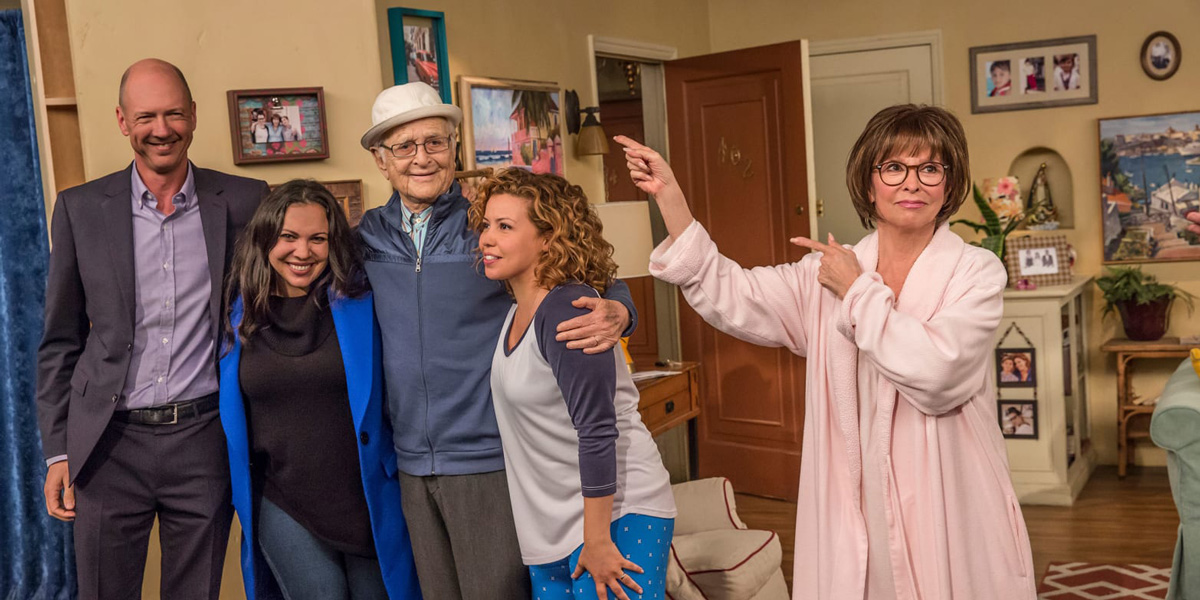 A behind-the-scenes photo of the cast of One Day at a Time with series creator Norman Leer.