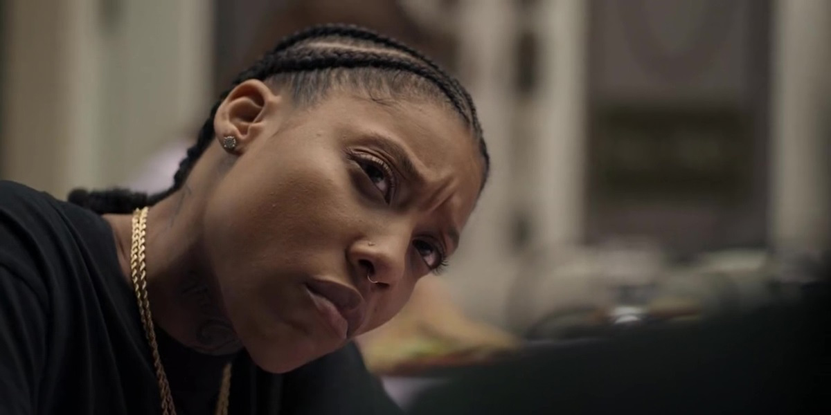 In Rap Sh!t Season 2 finale, Chastity is stunned to hear that Shawna and Mia are dropping her to work with Francois. (Shot is over Shawna's shoulder with Chastity looking at her seriously. Chastity is wearing all black except her gold chains.)