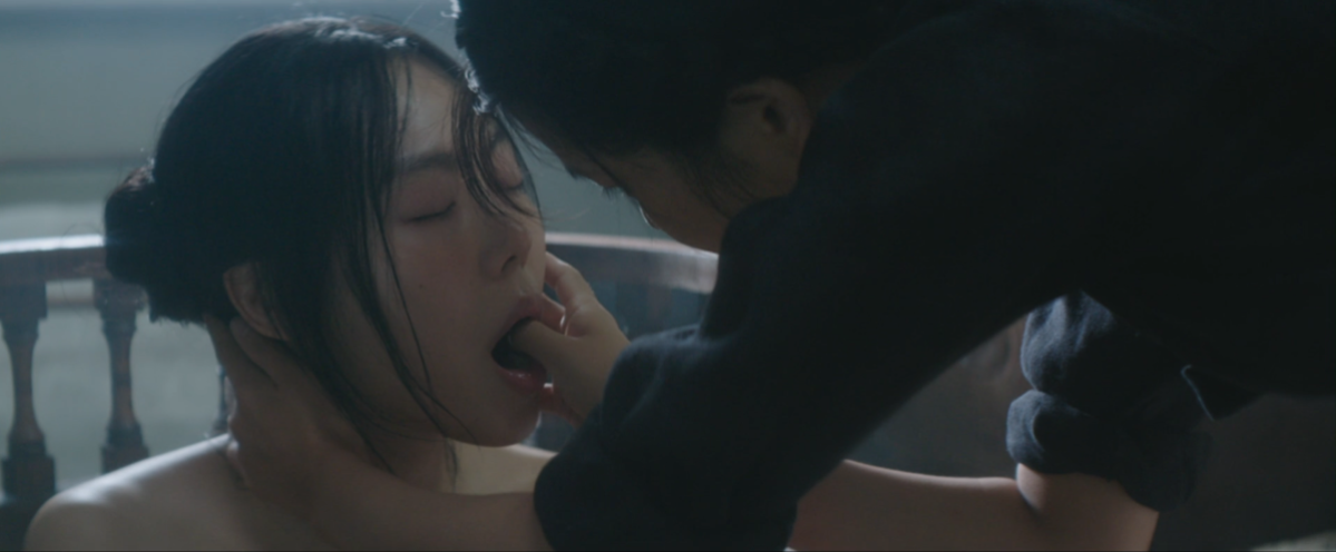 Sook-hee inserts her thumb in Hideko's mouth