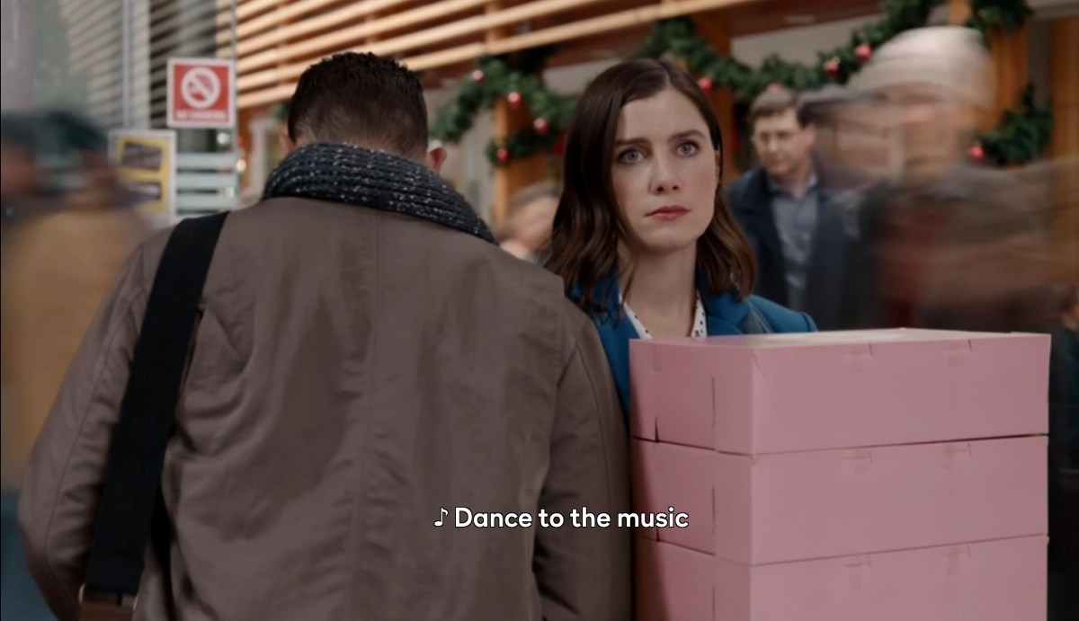 "Dance to the music" while she stands sad with boxes of donuts