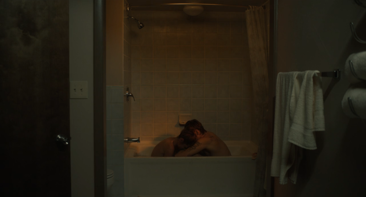 Harris Dickinson and Emma Corrin lean on each other in a bathtub.