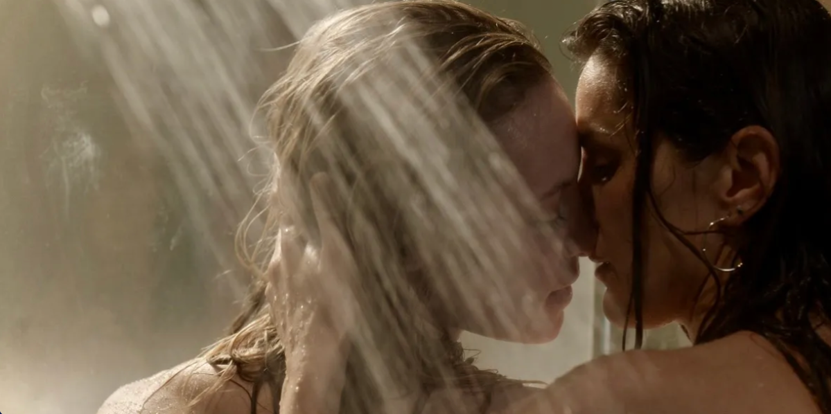Two white women kiss in a shower. 