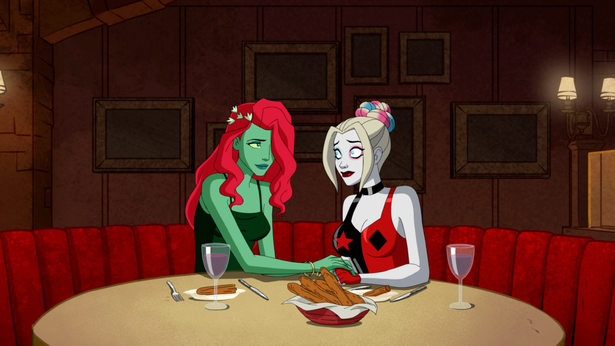 Harley Quinn and Poison Ivy hold hands in a booth at dinner.