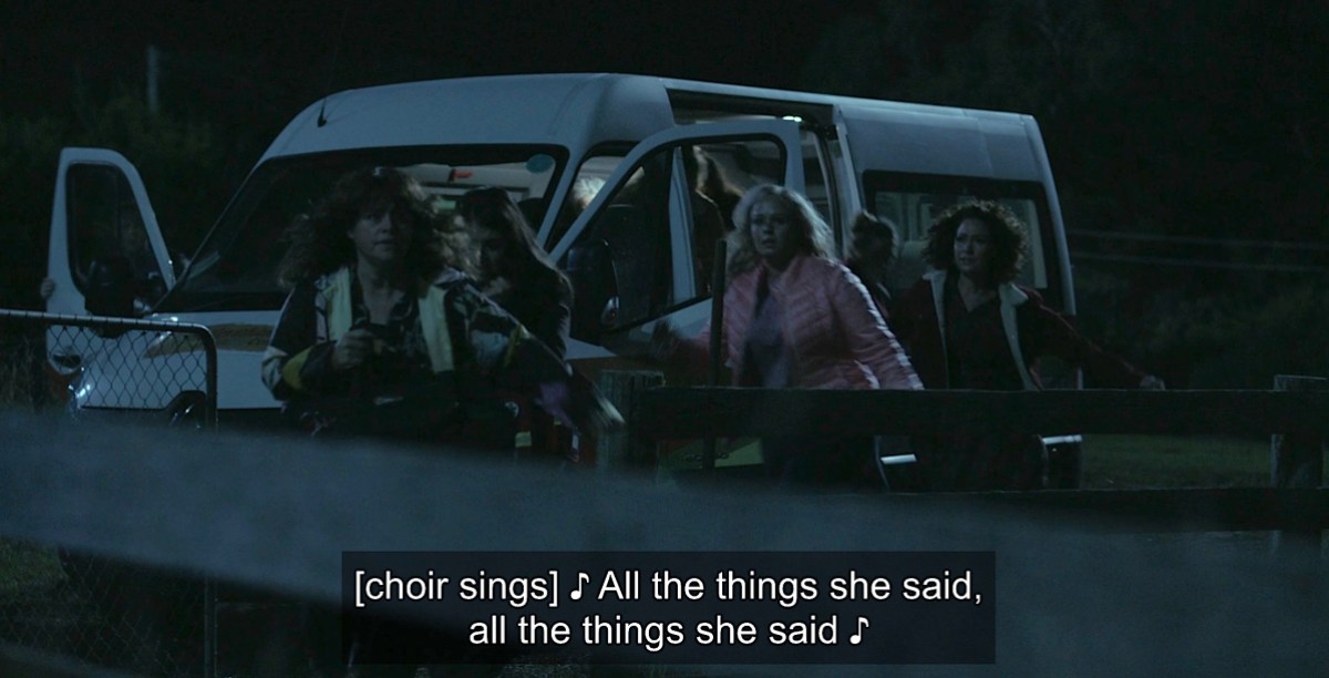 Best queer tv scenes of 2023: a dark image of a group of women exiting a white van with a subtitle saying "all the things she said all the things she said"