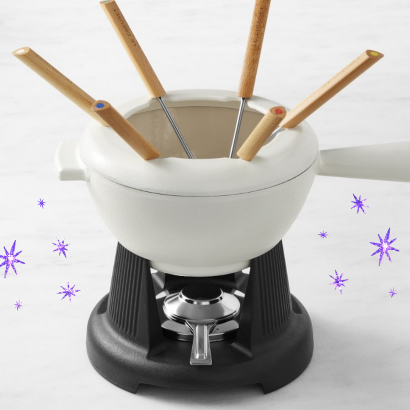 a mini fondue pot with skewers in it