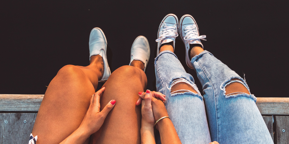 two women hold hands on a dock