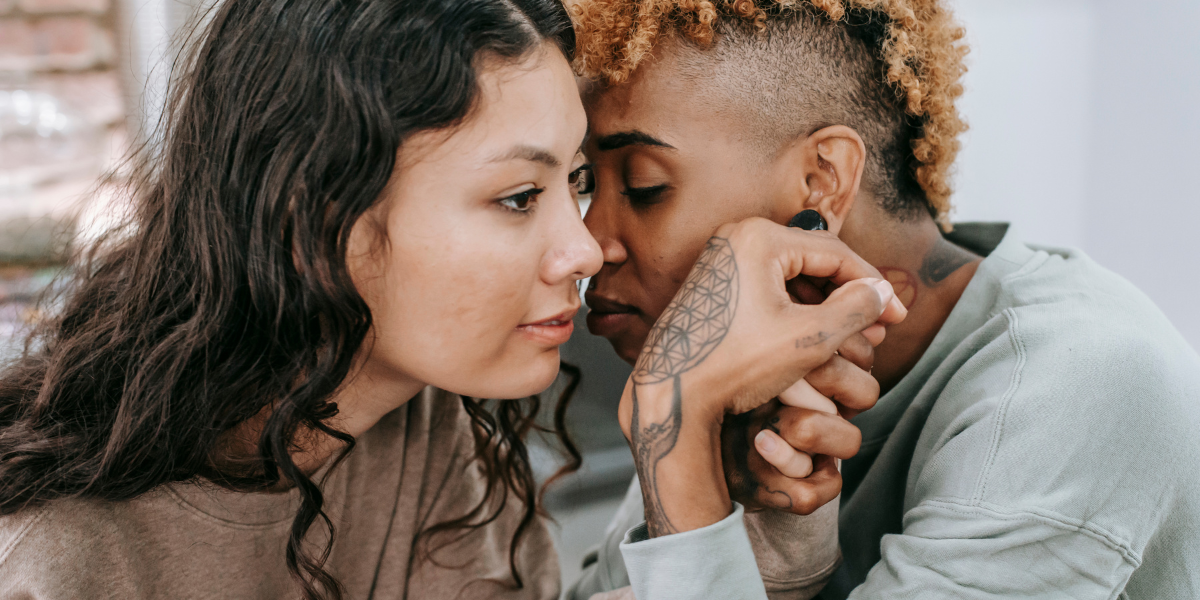 two women leaning in toward each other supportively