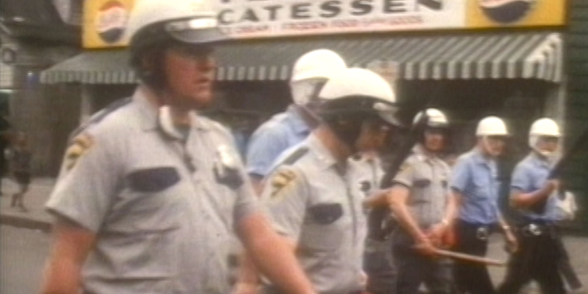 Power Netflix documentary: a row of white police officers in 1960s riot gear march forward.