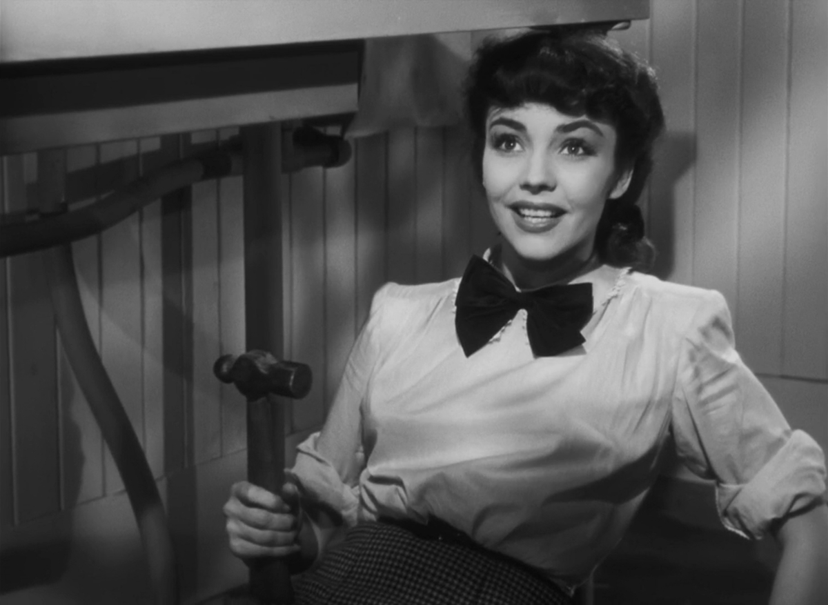 Jennifer Jones holds a hammer and wears a bowtie