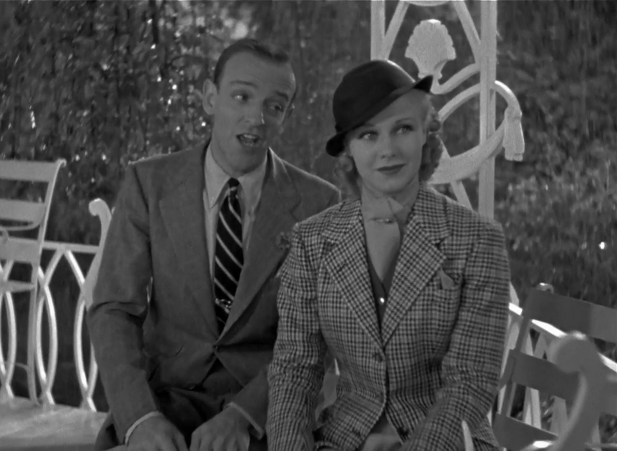 Ginger Rogers sits with Fred Astaire serenading her behind him