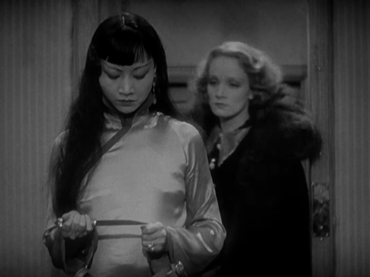 Anna May Wong grips a knife as Marlene Dietrich approaches behind her