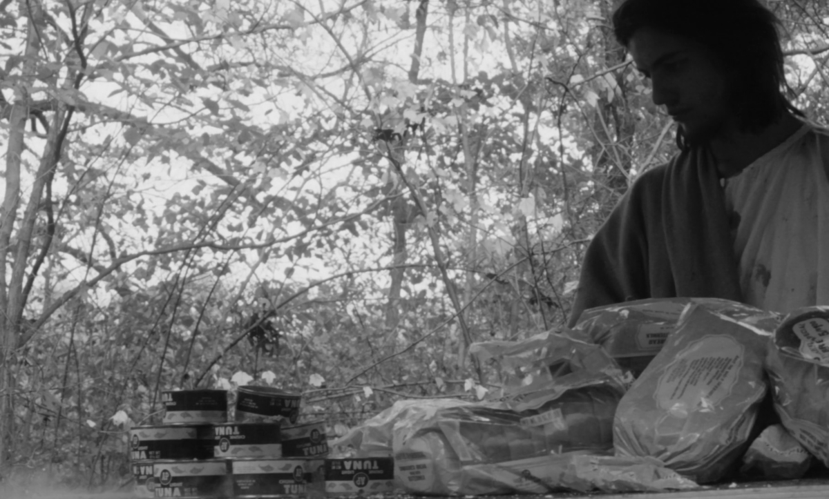 Jesus stands next to bags of bread and cans of tuna fish