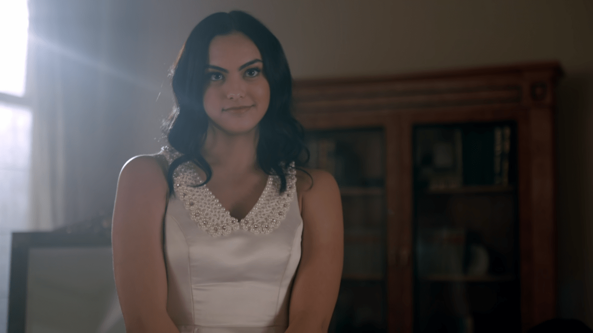 A medium close of Veronica Lodge smiling in her confirmation dress.