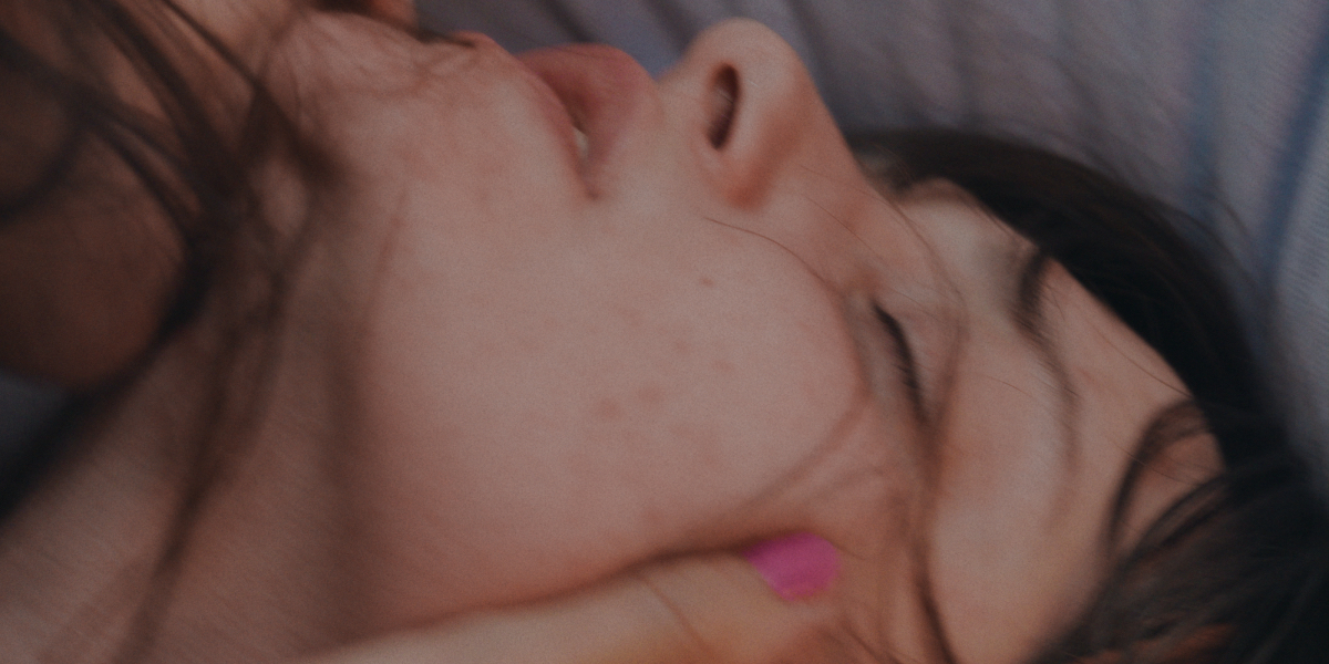 A close up of a blurry woman's face in ecstasy