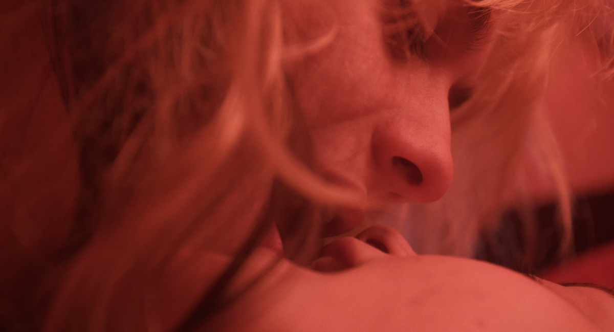 Stroking an Animal: close up of two women kissing in red light