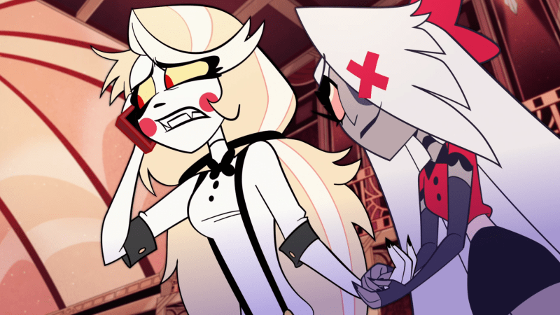 Hazbin Hotel: The queer princess of hell Charlie is on the phone and her girlfriend Vaggie holds her hand