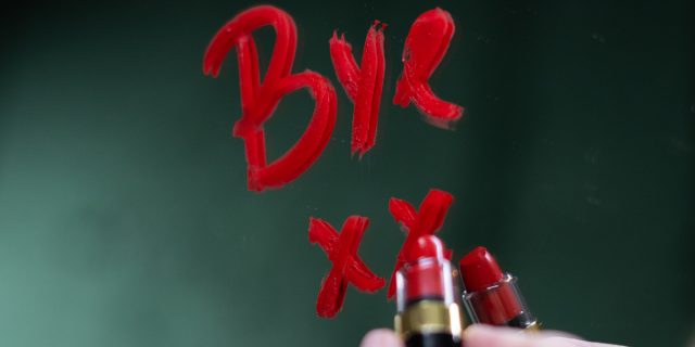 someone writing BYE XX in lipstick on a mirror