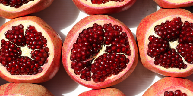 three fresh pomegranates that have been open