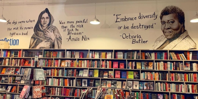 A bookstore with quotes painted above it from Anais Nin and Octavia Butler