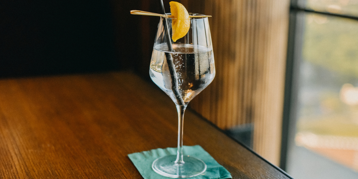 a glass of water in a wine glass with a lemon wedge