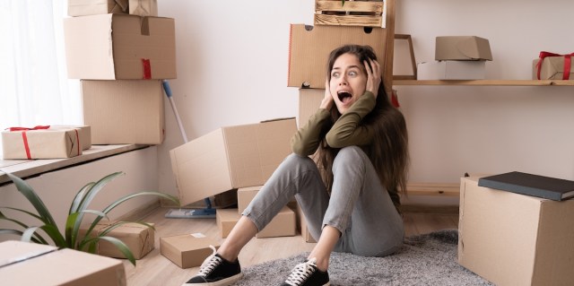 Stressed young woman surrounded by large boxes cry scream, no ready for home relocation, moving day concept