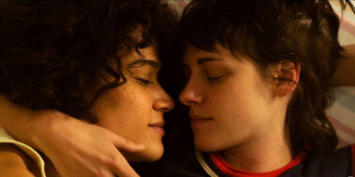 Kristen Stewart and Katy O'Brian lie in bed together in a close up in Love Lies Bleeding.