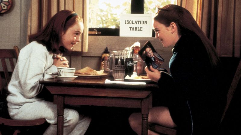 Lindsay Lohan plays two twins at summer camp eating at a table in The Parent Trap