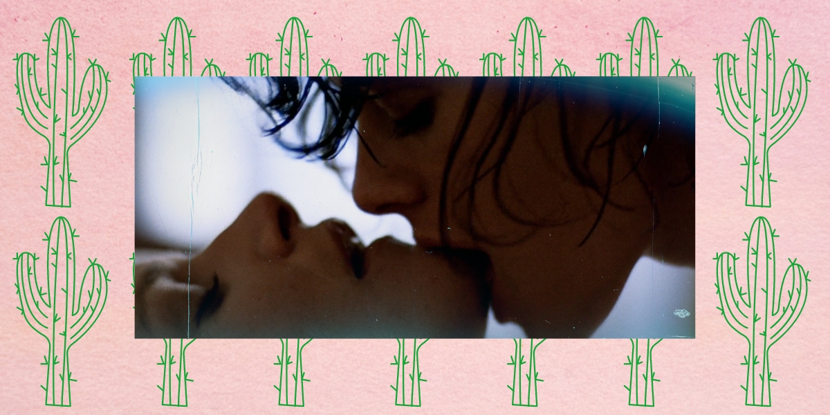 An image of Cay kissing Vivian's chin from the Desert Hearts sex scene against a pink backdrop with green cactus drawings
