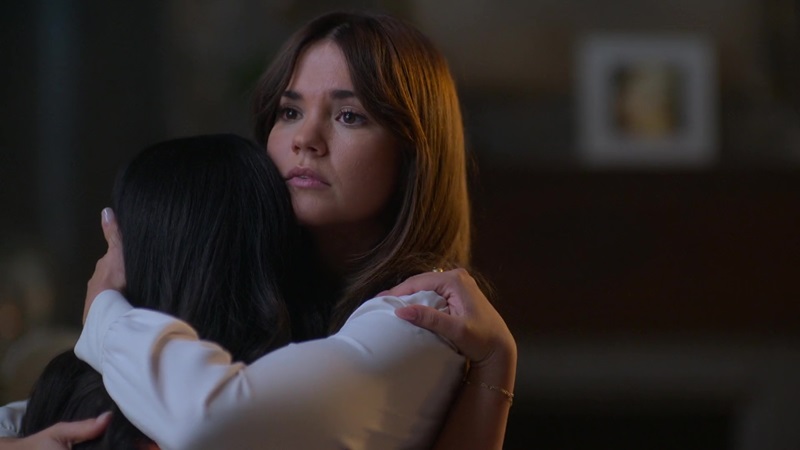 Callie tries to calm an anxious Mariana with a hug. Callie's wearing a white long sleeve blouse and, honestly, she's never looked better.