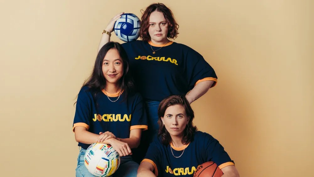 E.R. Fightmaster, of Grey's Anatomy fame, Tien Tran from How I Met Your Father, and Katie Kershaw from Killing It pose with various sports-balls for their new podcast "Jockular"